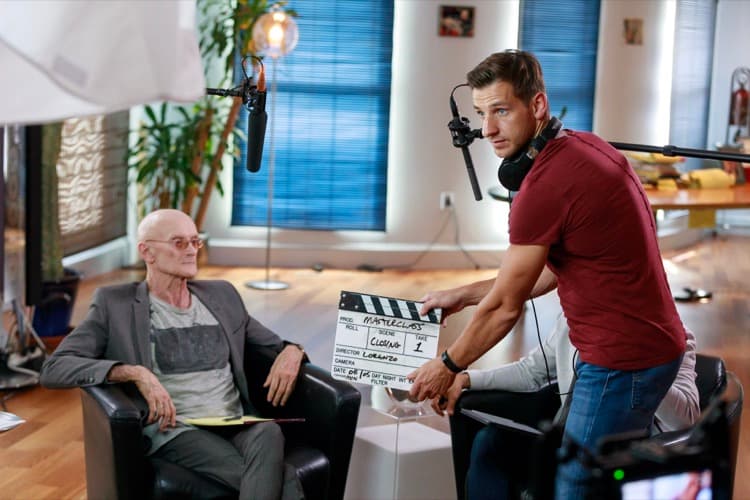 Delano directing a MasterClass film shoot, holding a clapperboard